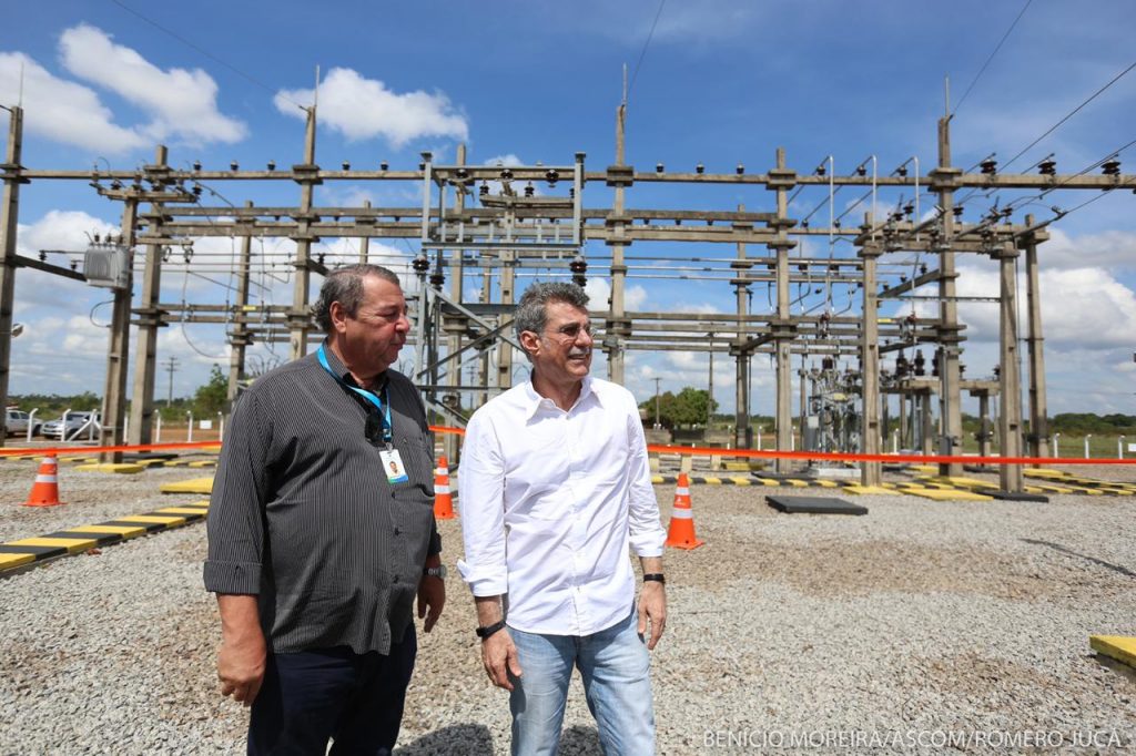 Jucá olha torres de parque de energia elétrica em Roraima acompanhando de outro profissional