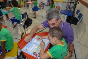 Romero Jucá e criança em sala de aula de Boa Vista