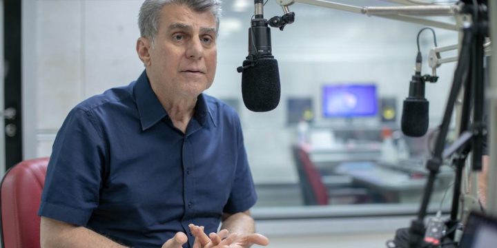 Romero Jucá falando no microfone em estúdio de rádio. Falou sobre a vida