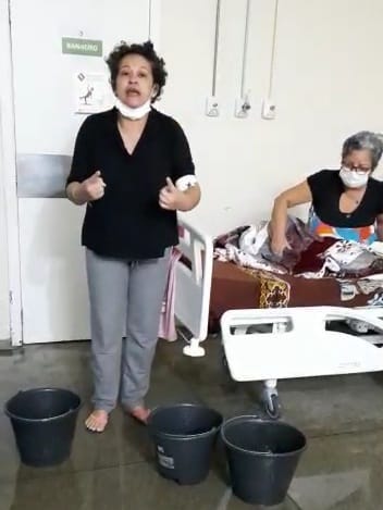 Pacientes internados no Hospital Geral de Roraima em quarto alagado pela água da chuva, com baldes na frente para aparar a água