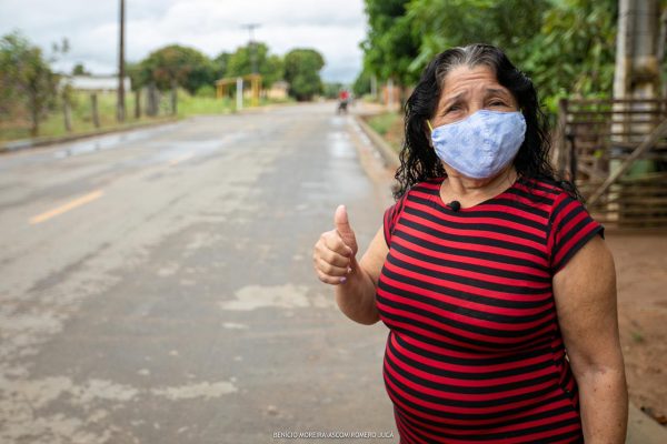 Ilda Mota faz sinal de positivo na rua em que mora. Lugar asfaltado é fruto da parceria com Iracema de Jucá. Asfalto na gestão de Jairo Ribeiro