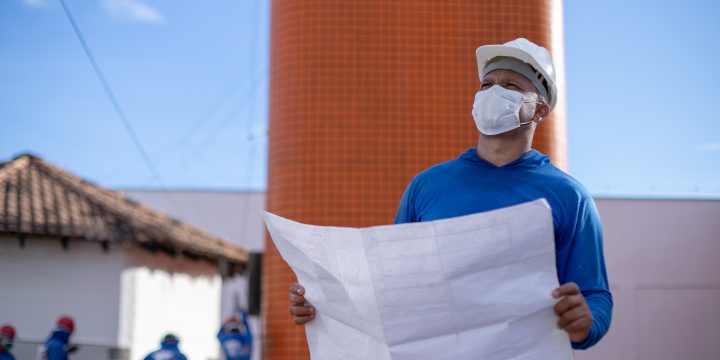 Magno Félix segurando uma planta baixa e olhando pra cima