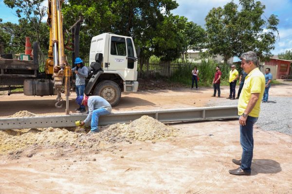 Romero Jucá olha homens colocando postes em Nova Colina